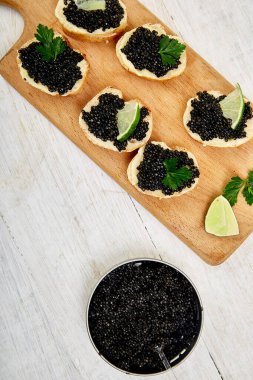 Siyah havyarlı sandviç. Tahta kasede siyah havyar, beyaz arka plan fotokopi alanında sandviç ve şampanya. Üst görünüm