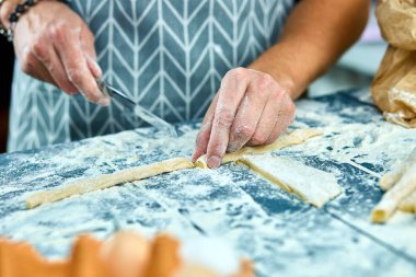 Ev yapımı makarna yapma closeup süreci. Şef ince kurdele İtalyan geleneksel makarna için bıçak taze hamur ile kesme pişirin. İtalyan mutfağı tarifi. Ev mutfağı. Koca mutfakta yemek pişirme.