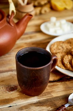 Öğleden sonra çayı, çay seremonisi, çaydanlık kurabiyeli bal bardakları, eski kırsal ahşap masa üzerinde bisküviler.