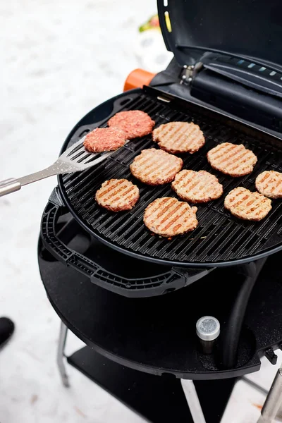 Hombre asar filetes en una barbacoa portátil, Nevado barbacoa de invierno —  Fotos de Stock