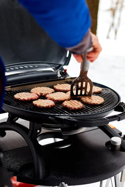 Hombre asar filetes en una barbacoa portátil, Nevado barbacoa de invierno — Foto de Stock