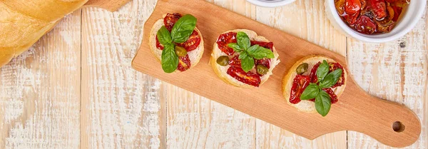 Banner with Bruschetta or crostini with sun dried tomatoes and capers — Stock Photo, Image