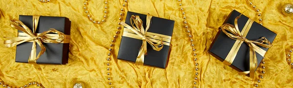 Banner con cajas de regalo negras de lujo con cinta de oro — Foto de Stock