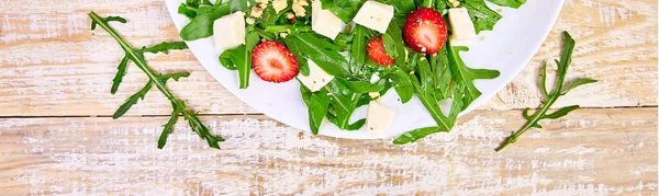 Färsk sallad med ruccola, jordgubbar, fetaost och nötter. — Stockfoto