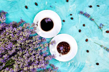 Yukarıdan mavi arka plan üzerinde kahve ve lavanta çiçeği. Günaydın konsepti. Kadın çalışma masası. Rahat kahvaltı. Mockup. Düz döşeme stili