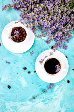 Yukarıdan mavi arka plan üzerinde kahve ve lavanta çiçeği. Günaydın konsepti. Kadın çalışma masası. Rahat kahvaltı. Mockup. Düz döşeme stili