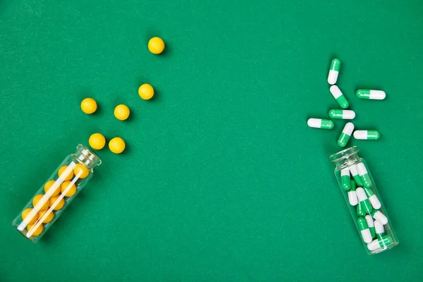 医療ブログのためのミニマリズムスタイルのテンプレート 小さなガラス瓶小さな黄色と緑の錠剤は 紙の背景をこぼしました 医薬品の概念 薬の薬フラットレイ — ストック写真
