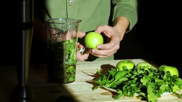 在用搅拌机制备绿色脱氧核糖核酸的过程中 年轻人将苹果切碎并放入 用新鲜水果和绿色菠菜烹调健康的脱氧核糖核酸 生活方式排毒的概念 冰岛人喝酒 — 图库视频影像