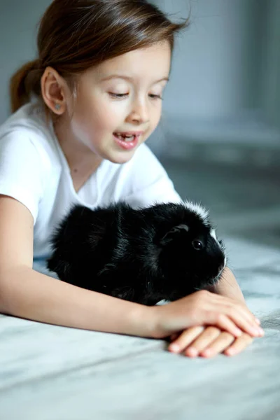 Egy Boldog Mosolygó Kislány Portréja Amint Fekete Tengerimalacot Ölelget Imádnivaló — Stock Fotó