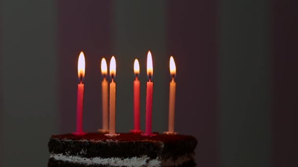 Tarta de cumpleaños con velas encendidas sobre fondo rosa — Vídeos de Stock