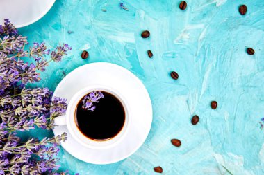 Yukarıdan mavi arka plan üzerinde kahve ve lavanta çiçeği. Günaydın konsepti. Kadın çalışma masası. Rahat kahvaltı. Mockup. Düz döşeme stili