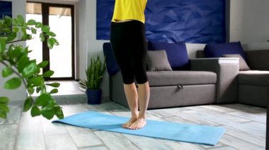 Kıdemli kadın evde çalışıyor, yoga yapıyor ya da pilates yapıyor..