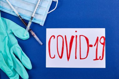 Coronavirus ya da Covid 19 korunması için nesneler. El dezenfeksiyonu, jel sıkmak, maske takmak ve eline hap sıkmak demektir. Mavi bir arka planda düz uzandı.