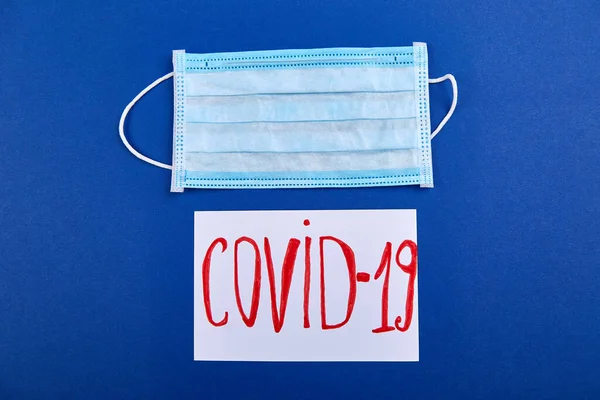 Coronavirus Phrase Text Flat Lay Protective Face Mask Blue Background — Stock Photo, Image