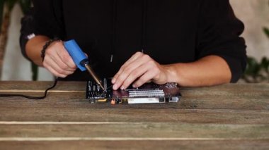 Mühendis ya da teknisyen lehim demiriyle elektronik devre kartını tamir ediyor. İnsan askerlere bilgisayar devre kartını lehimleme demiriyle veriyor. Boşluğu kopyala.