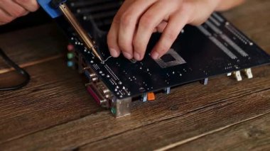 Mühendis ya da teknisyen lehim demiriyle elektronik devre kartını tamir ediyor. İnsan askerlere bilgisayar devre kartını lehimleme demiriyle veriyor. Boşluğu kopyala.