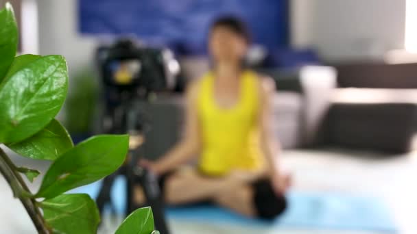 博客的资深女性 身材纤细 穿着运动服 在网上记录视频 在家里的瑜伽垫上摆着荷花 Fitness博客 在线培训 Coronavirus检疫室 呆在家里 — 图库视频影像