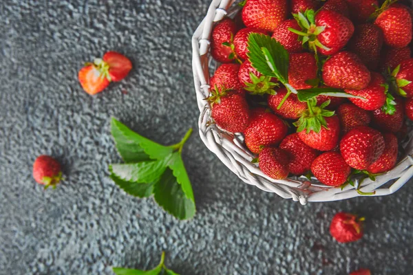 Ripe red strawberries on black background, Strawberries in white basket. Fresh strawberries. Beautiful strawberries. Diet food. Healthy, vegan. Top view. Flat lay.