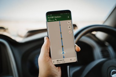 Sürücü araba sürerken cep telefonu navigasyonu kullanıyor