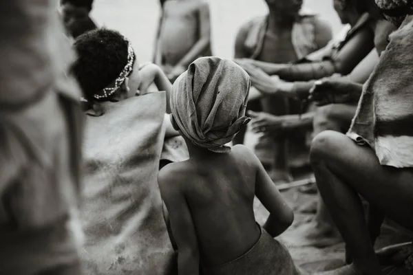 Siyahi ve beyazlardan oluşan bir grubun arkasından Afrikalı bir çocuk.