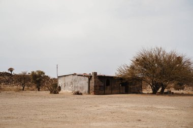 Çöldeki bir Afrika köyünde asfaltsız yolda boş bir ev.