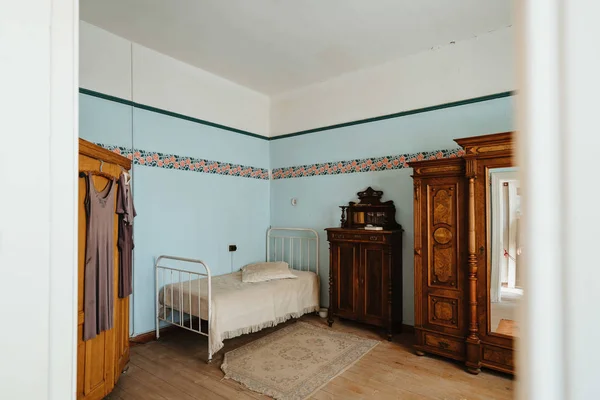 Interior of colonial blue sleeping room with bed and shelves — ストック写真