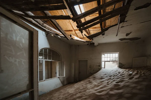 Bela vila ocidental com grandes janelas e areia do deserto cobrindo o chão — Fotografia de Stock