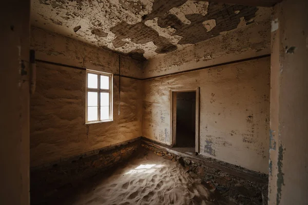 Du sable du désert pénètre dans un vieux bâtiment abandonné et se désintègre — Photo