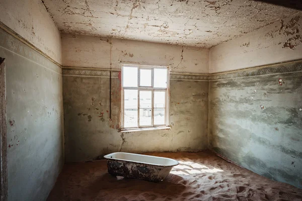 Sable désert entrant dans un ancien bâtiment abandonné avec baignoire — Photo