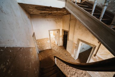 Terk edilmiş evdeki eski merdivenler kum dolu, Kolmanskop Hayalet Kasabası