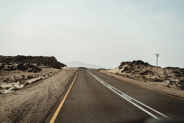 Estrada vazia através das dunas do deserto com espaço de cópia — Fotografia de Stock