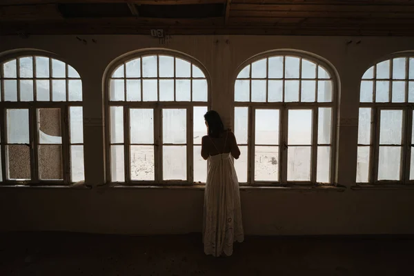 bride looking outside windows of an old colonial villa