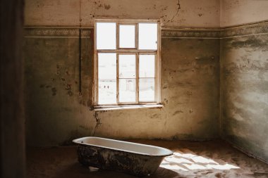 Luderitz yakınlarındaki Namib Çölü 'nde bulunan Kolmanskop harabelerinde eski bir hamam borusu.