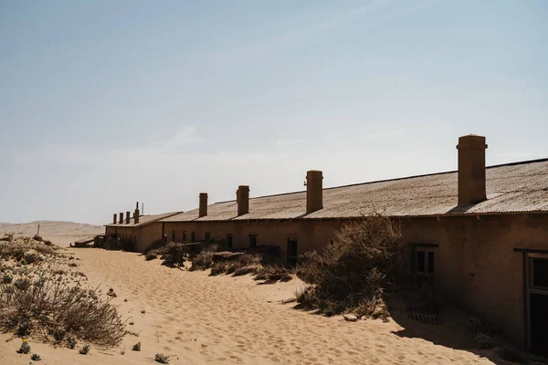 Edificios abandonados dejados a pudrirse en un paisaje salvaje del oeste con arena del desierto — Foto de Stock