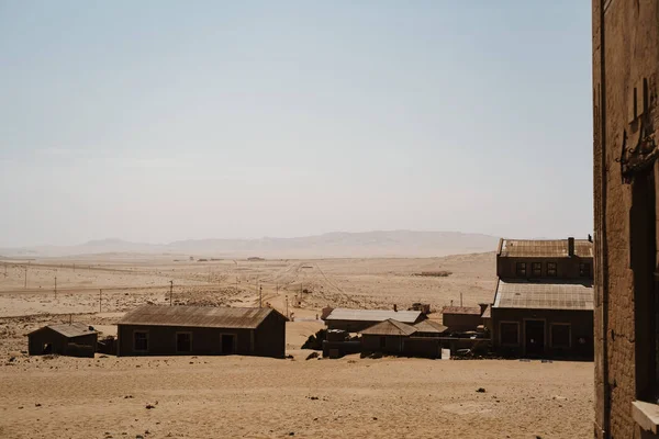 Vista exterior y viejo desierto edificando sobre otras casas abandonadas en la arena — Foto de Stock