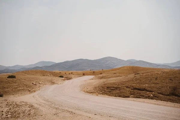 Sivatagi kavicsos út keresztül a szürreális Hold táj — Stock Fotó