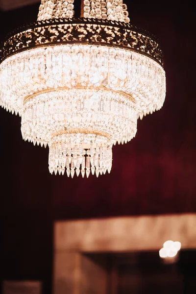 Big crystal chandelier hanging inside red room — Stock Photo, Image