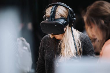 Sanal gerçeklik kulaklığı takan isimsiz bir kadın.