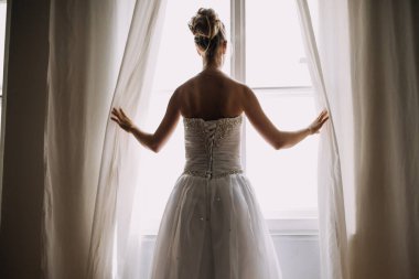 Pencereden dışarı bakan zarif, güzel gelin.