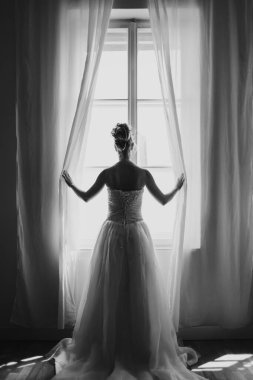 Pencereden dışarı bakan zarif, güzel gelin.