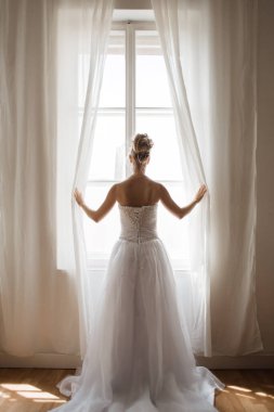 Pencereden dışarı bakan zarif, güzel gelin.