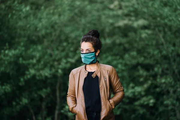 Foto di donna nella foresta che indossa una maschera facciale — Foto Stock