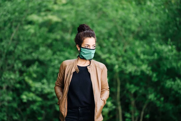 Foto de una joven en el bosque con una máscara facial — Foto de Stock