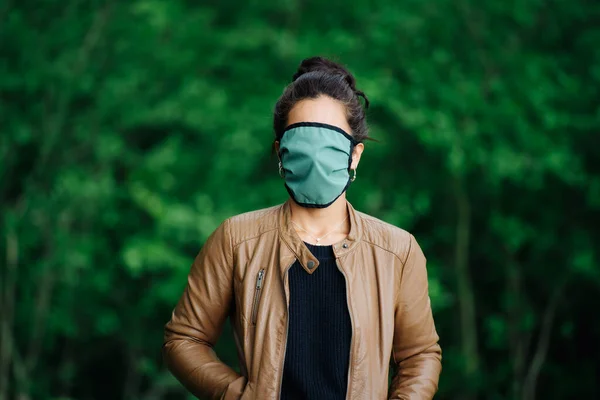 Foto de una mujer con una máscara que cubre su rostro en la naturaleza — Foto de Stock