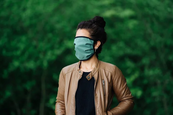 Fotó egy nőről, aki arcmaszkot visel, és eltakarja az arcát a természetben — Stock Fotó