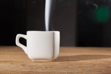 sabah kahvaltı bir meşe masada koyu arka plan üzerine bir fincan üzerinde buhar