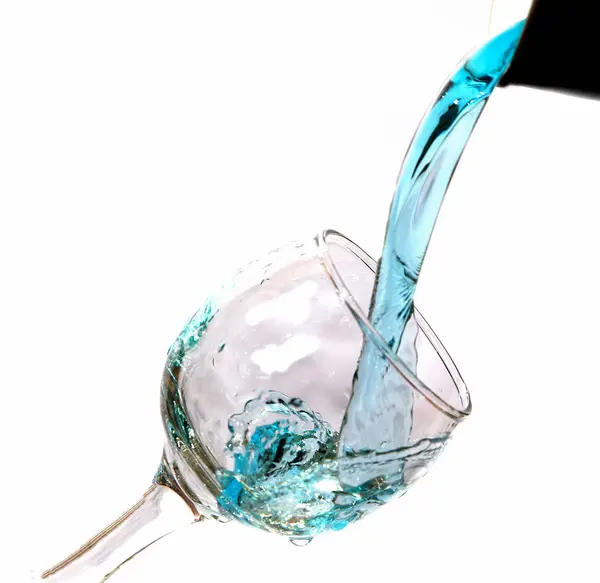 Падающая вода в стакане на белом — стоковое фото