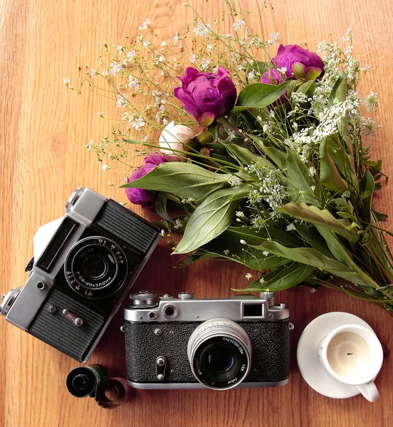 Винтажная камера возле букета цветов и свечей — стоковое фото