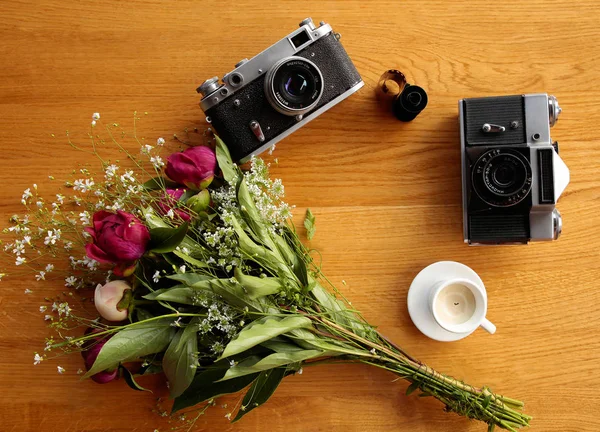 Vintage camera near a bouquet of flowers and candles — Stock Photo, Image