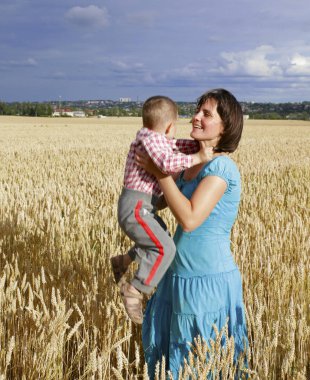  Genç anne oğlu ile bir buğday sahada oynuyor. Microstock fotoğraf